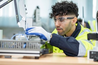  A man in safety gear operates a machine, ensuring safety and precision in his work environment.