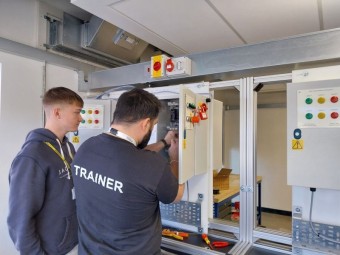 Dominic teaching a learner on the electrical training rig.